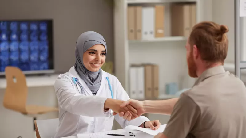 Female doctor shaking hands with a patient 
