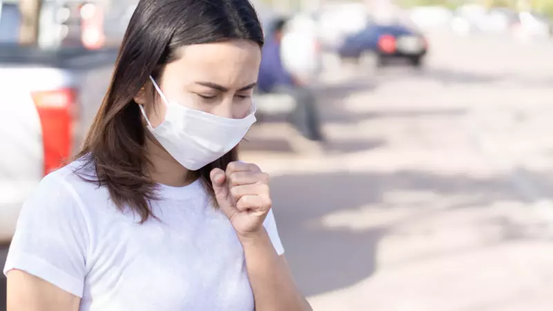 Women wearing a white mask and coughing 